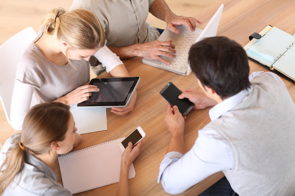 Group of business people using electronic devices at work-1